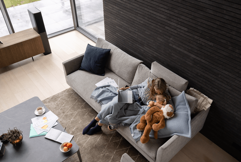 Mother and daughter using laptop while sitting on the sofa.