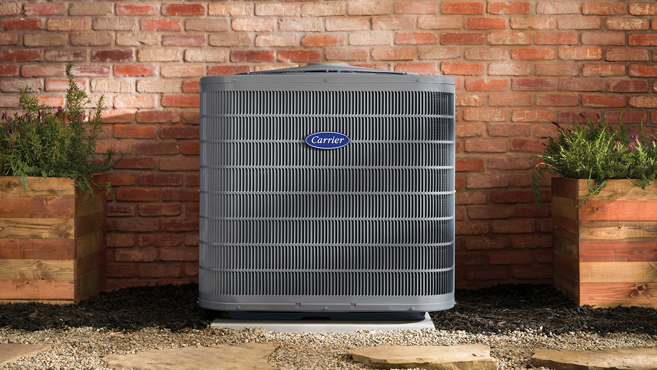 A Carrier Performance Series air conditioner installed outside a brick home