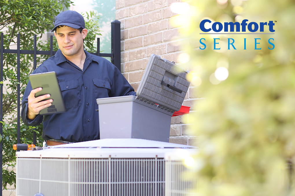 A dealer servicing a Comfort Series air conditioner with a Comfort Series logo nearby