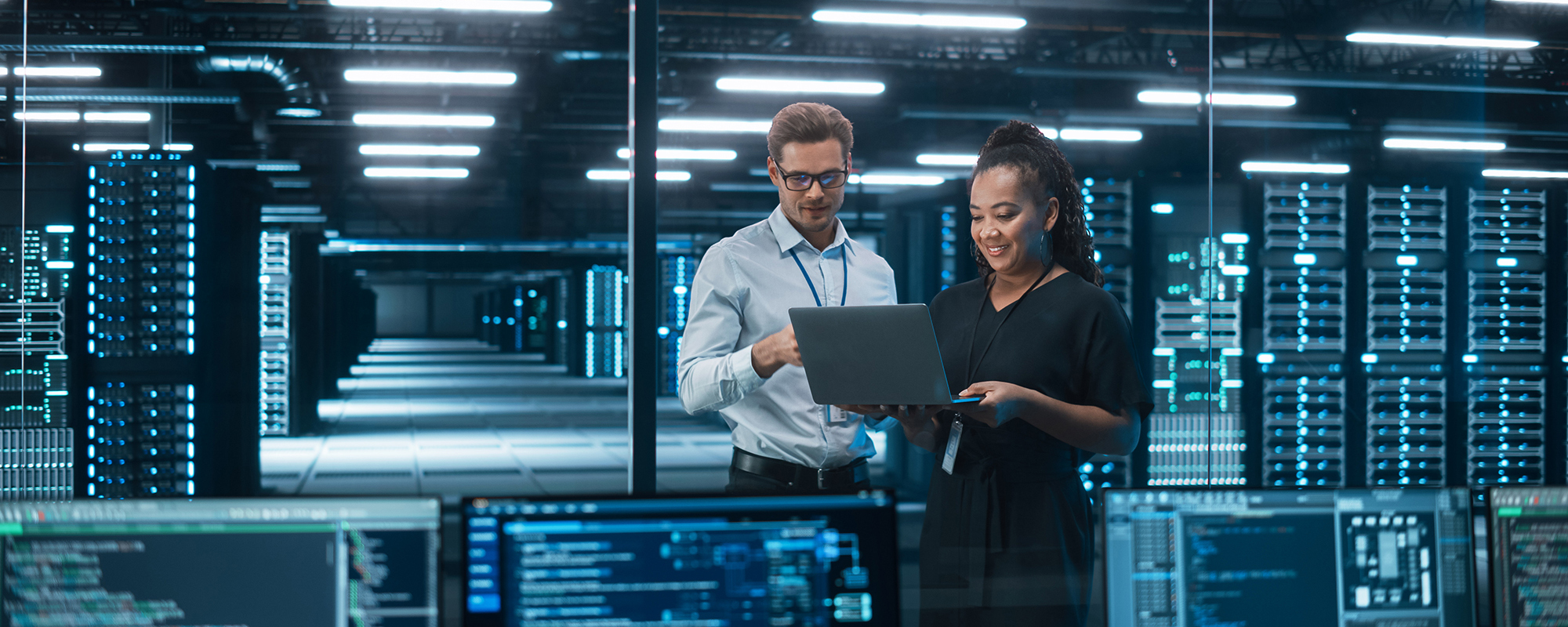 Man and woman looking at a laptop in a data center