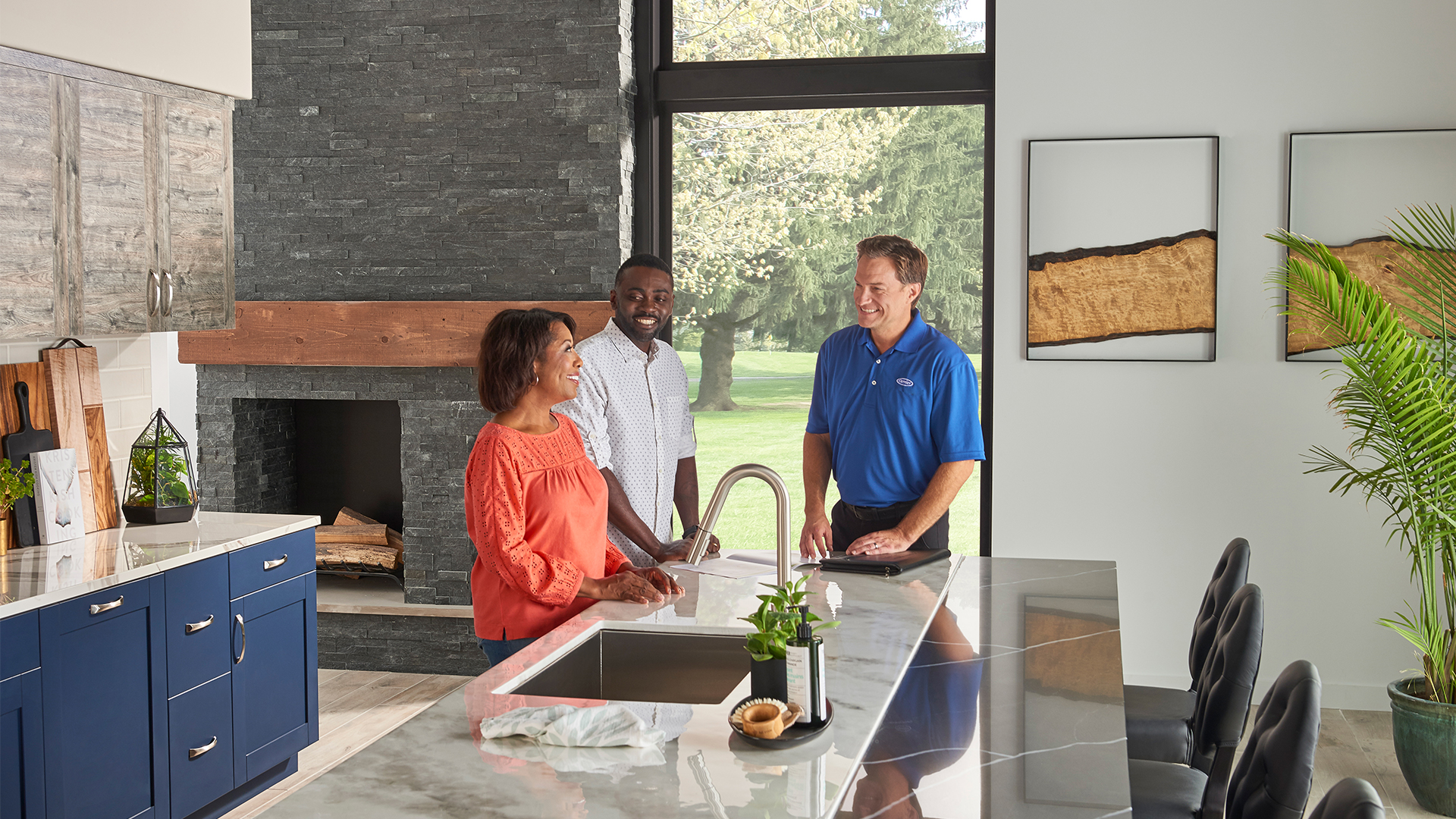 Carrier dealer talking air conditioner sizes with couple in their kitchen
