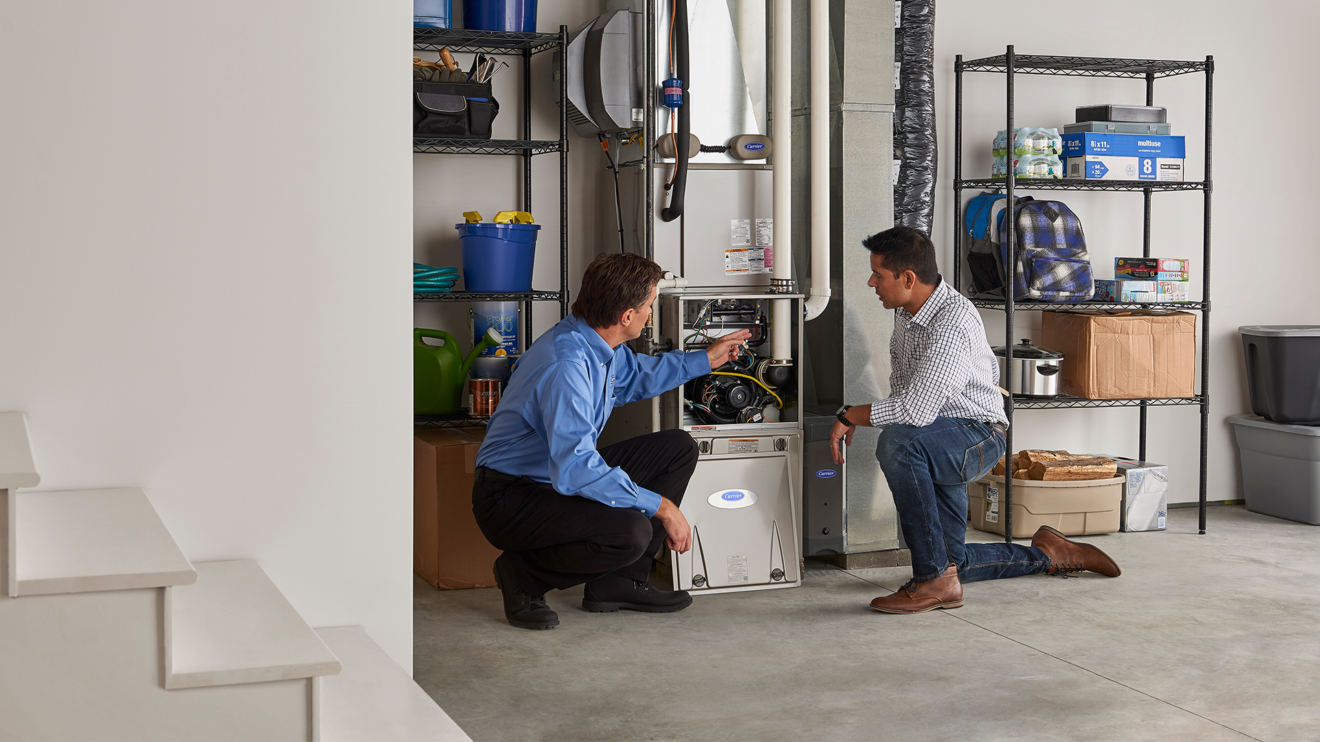 Carrier dealer explaining to a customer at home how a gas furnace works