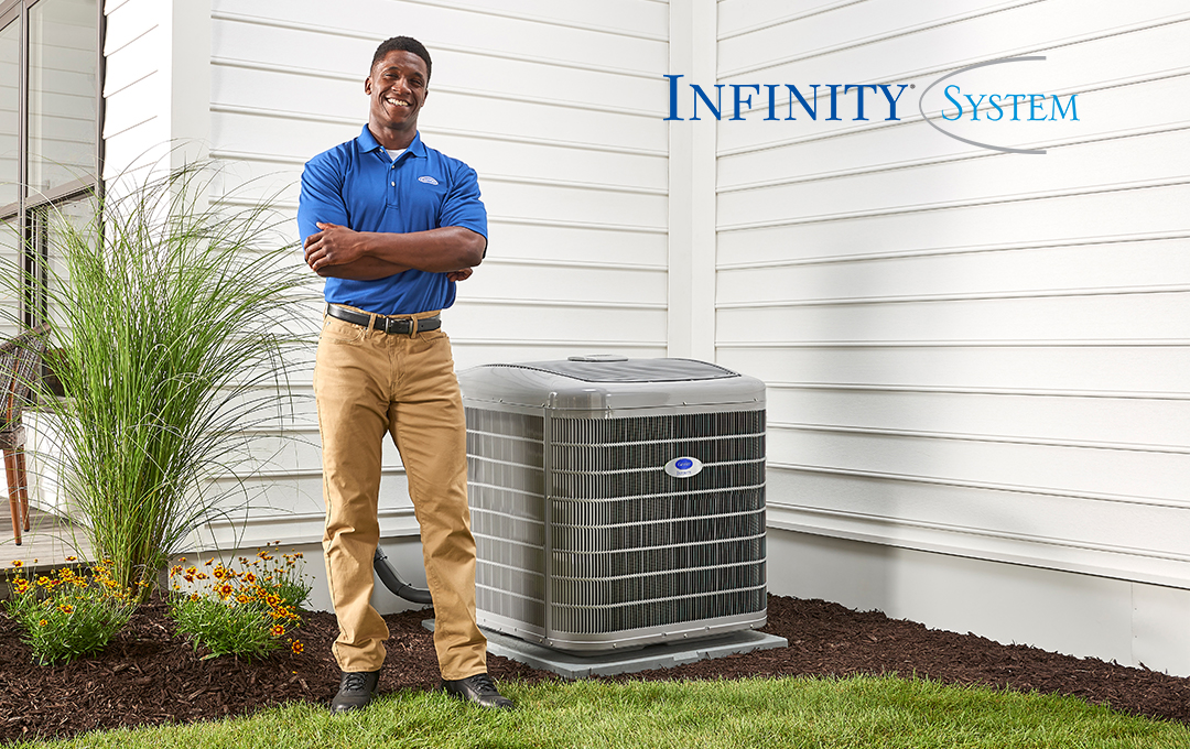 An Infinity System heat pump installed outside a home with blue siding with an Infinity System logo nearby