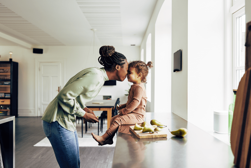 Mom and her little girl having a snack at home.