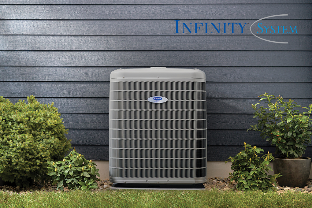 An Infinity System air conditioner installed outside a home with blue siding with the Infinity system logo nearby