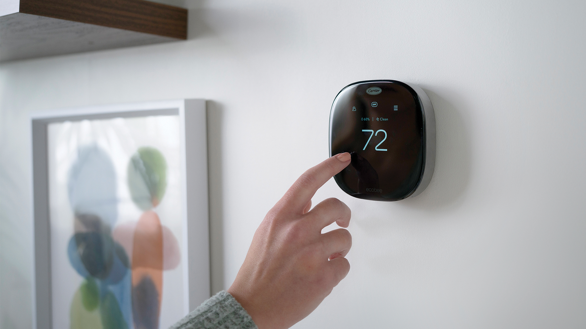 woman changing setting on ecobee thermostat