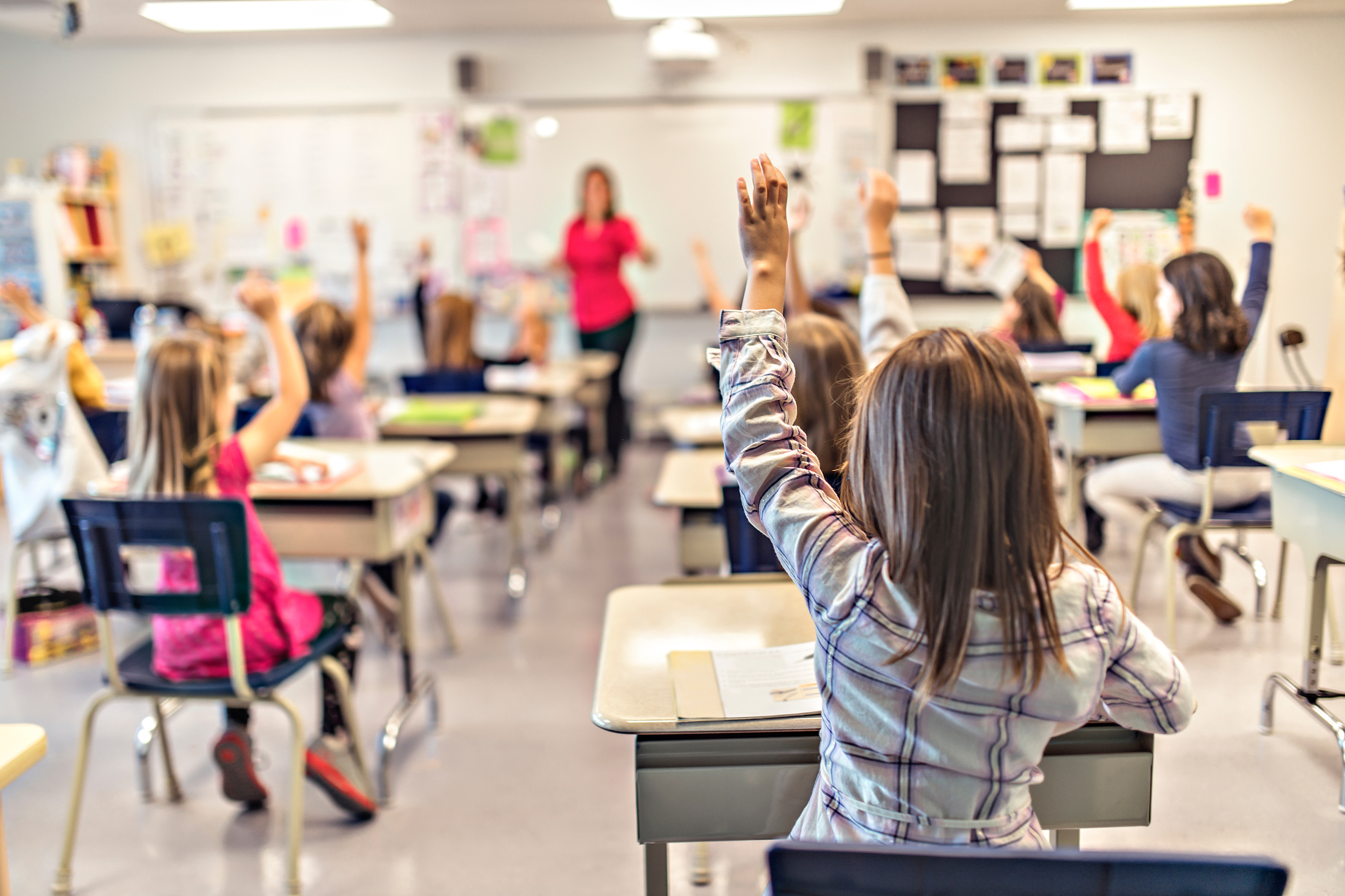 Elementary students writing on a class in the classroom