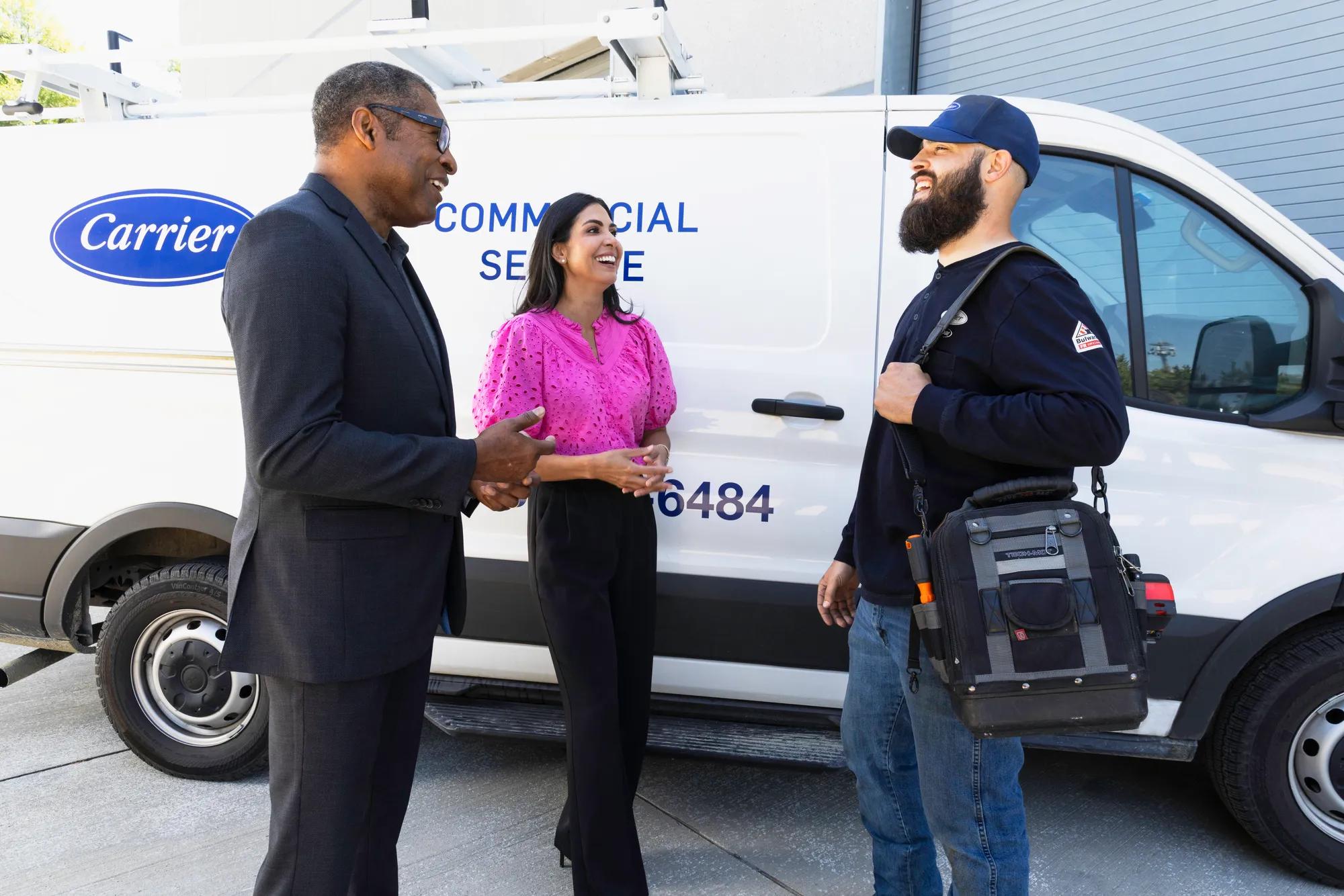 People talking in front of Carrier vans