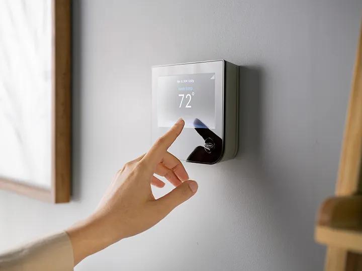 Dealer speaking with homeowners next to smart thermostat
