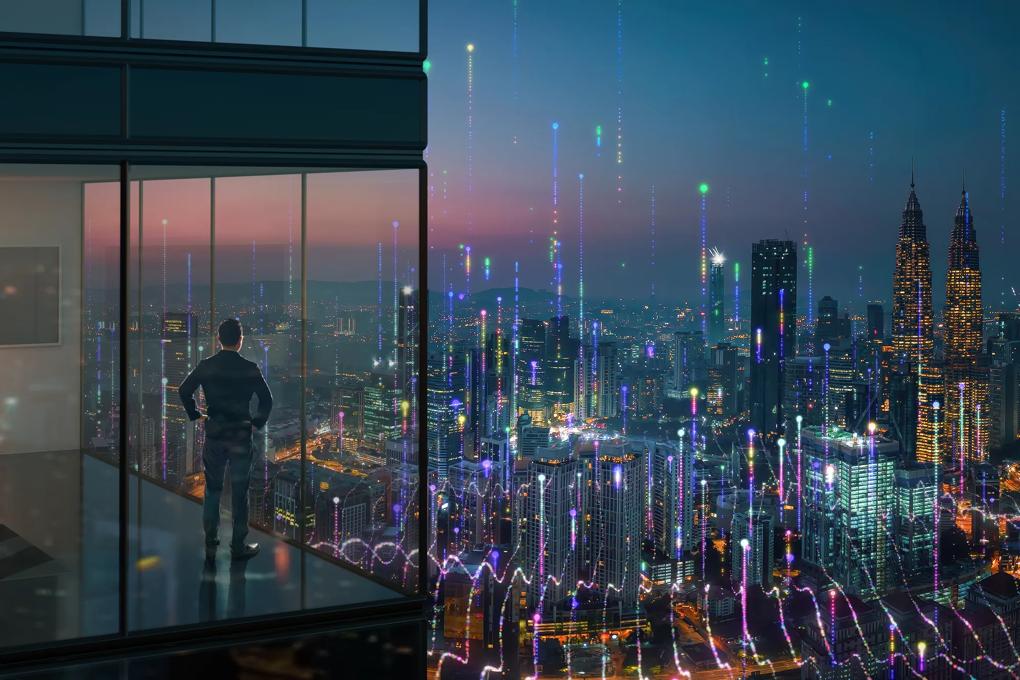man looking at city skyline at night