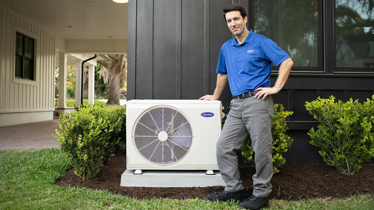 Certified Ductless Pro standing next to a heat pump