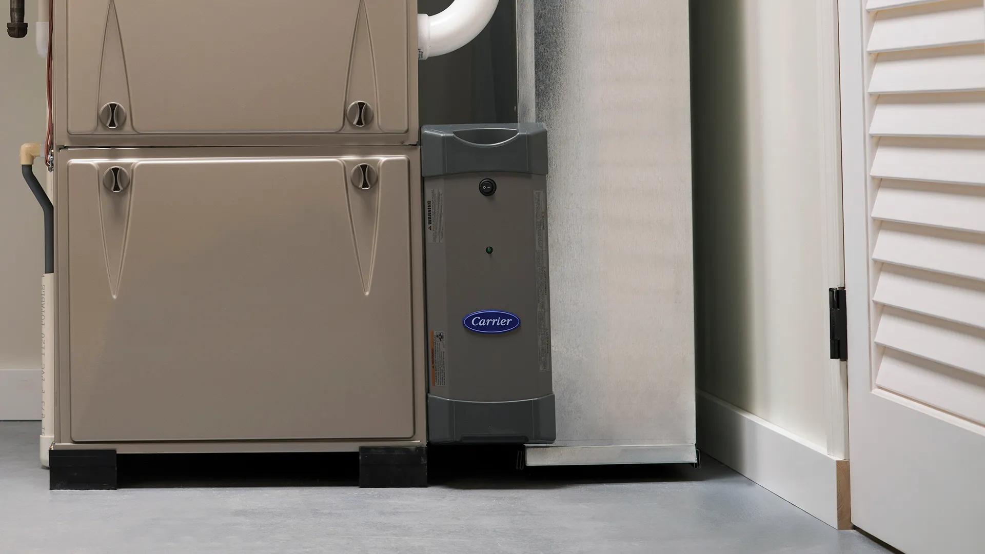 An Infinity whole house air purifier installed next to a furnace