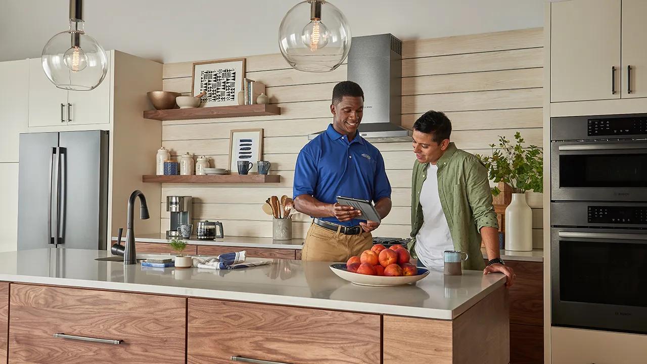 A Carrier dealer showing a man boiler product information on his Ipad