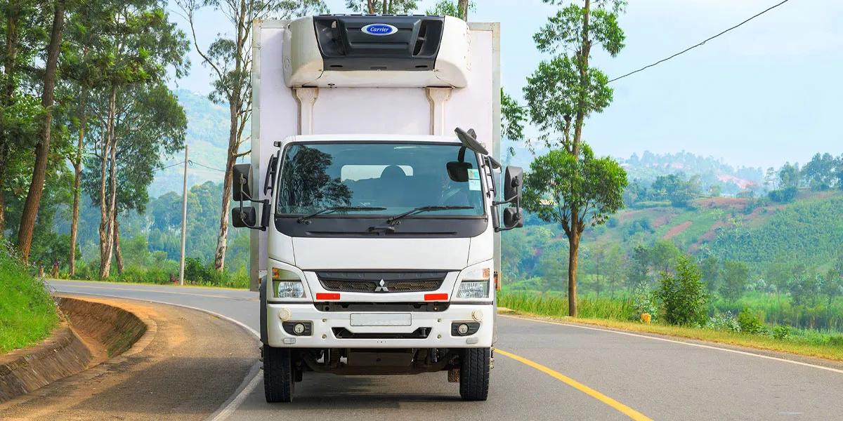 Box truck with Carrier refrigeration unit driving on road in Rwanda