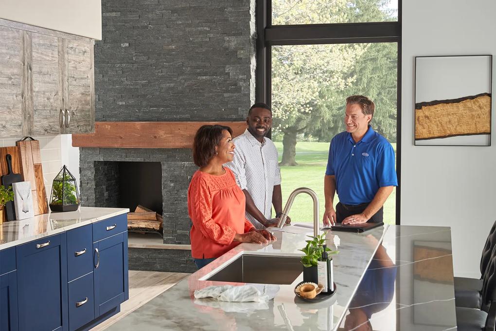 Dealer discussing heat pumps with customers at kitchen table