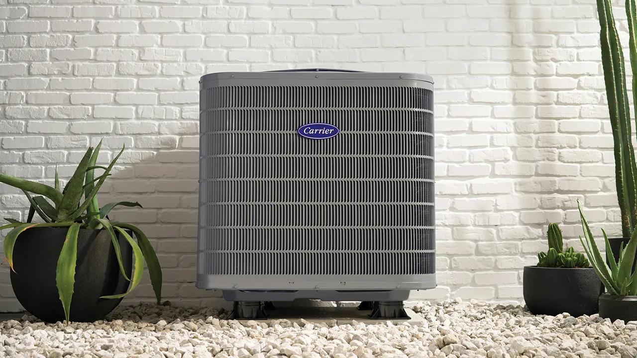 A Carrier Performance Series heat pump installed outside a brick home