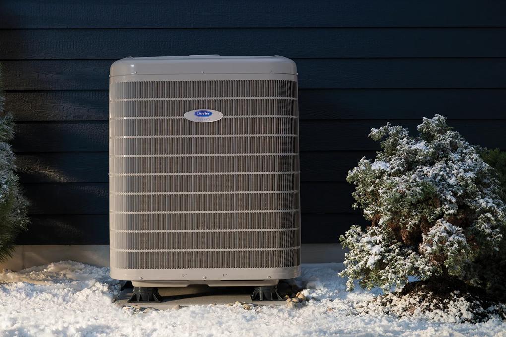 Heat pump outside a snowy home