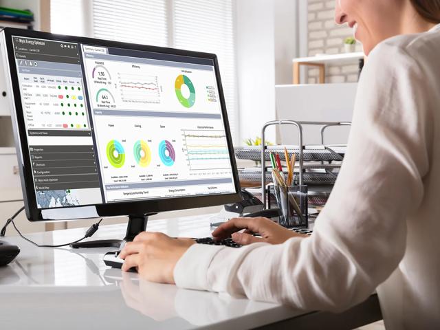 Woman using computer with Nlyte application on monitor