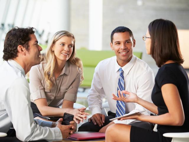 group of people talking in office building lobby