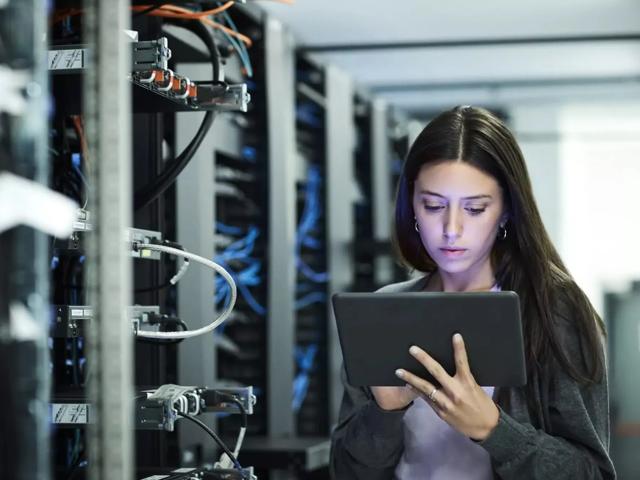young girl on laptop in server room