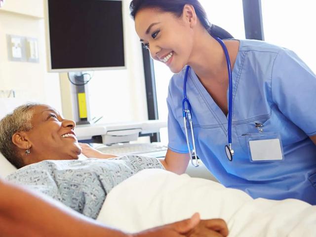 woman in hospital bed with nurse and doctor