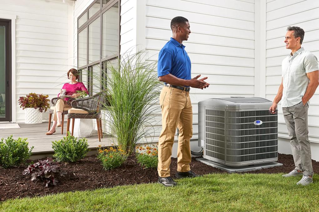 Dealer speaking with homeowner about heat pump outside