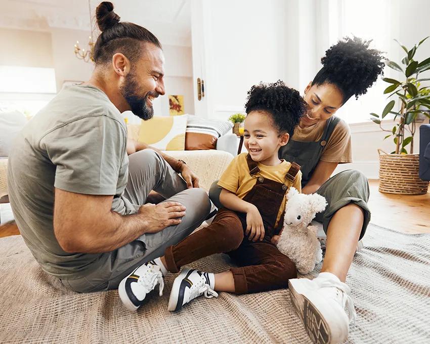 A young family comfortably sitting on the floor 
