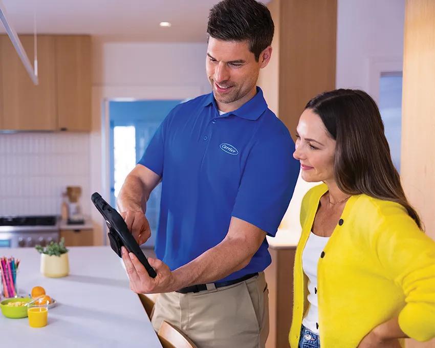 A Carrier dealer showing a woman evaporator coil features on an iPad