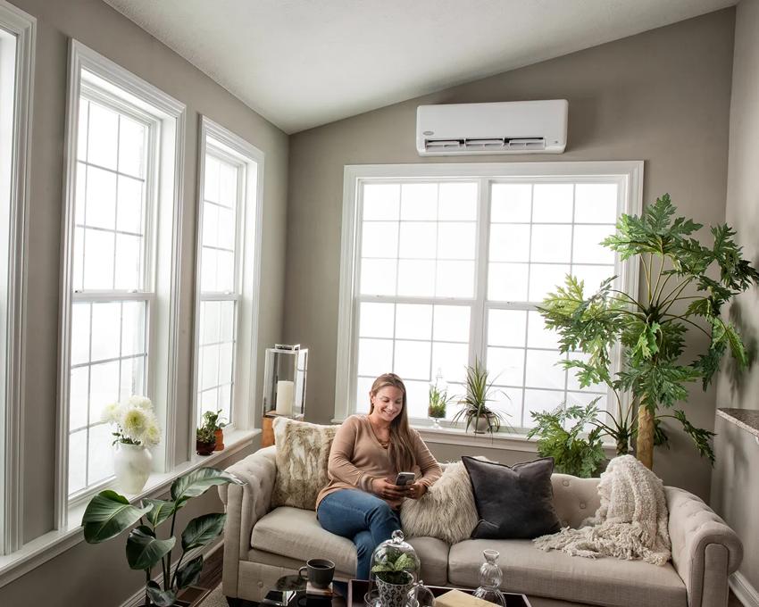 Woman enjoying new ductless mini split in sunroom