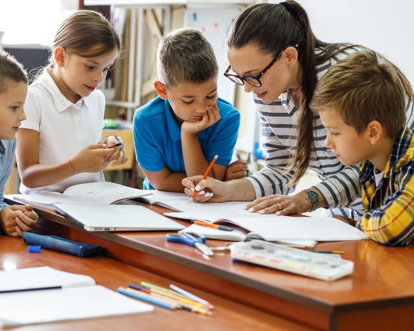 A kind female teacher spends time with her elementary school students, making learning enjoyable and fun