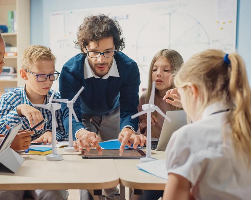 male teacher helping students in classroom