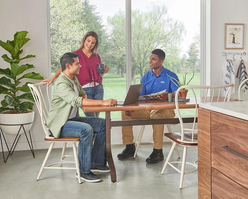 Dealer discussing prices with homeowners at kitchen table