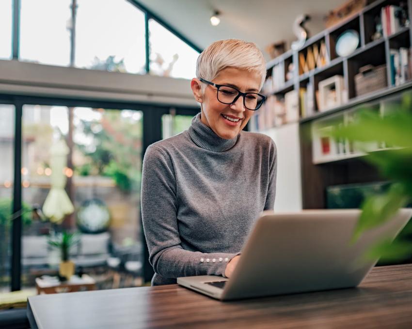 Businesswoman working on laptop at home office.