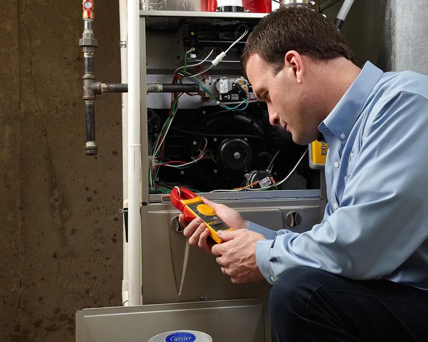 A Carrier dealer inspecting the age and condition of a furnace