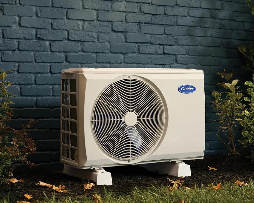 Mini split heat pump installed outside a home with blue bricks