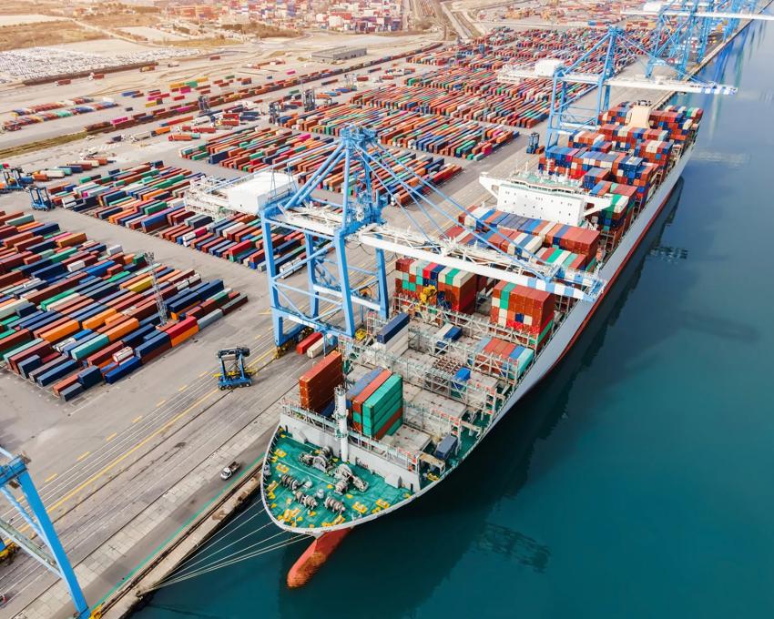 Container ship being loaded and unloaded at terminal freight port.