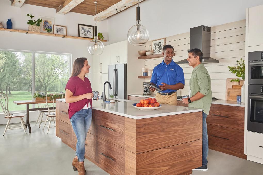 Carrier dealer talking with couple in their kitchen