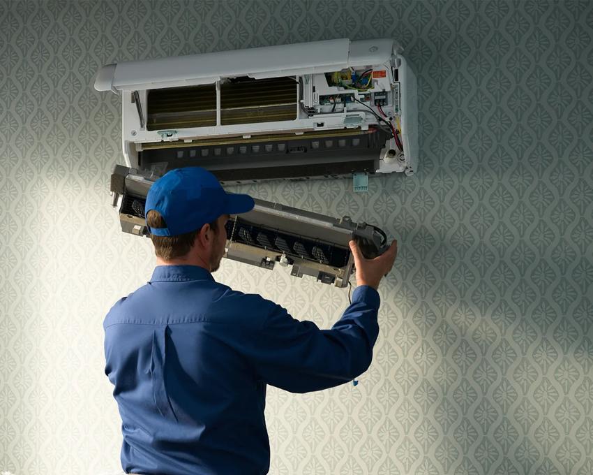Carrier technician performing maintenance on a mini duct handler
